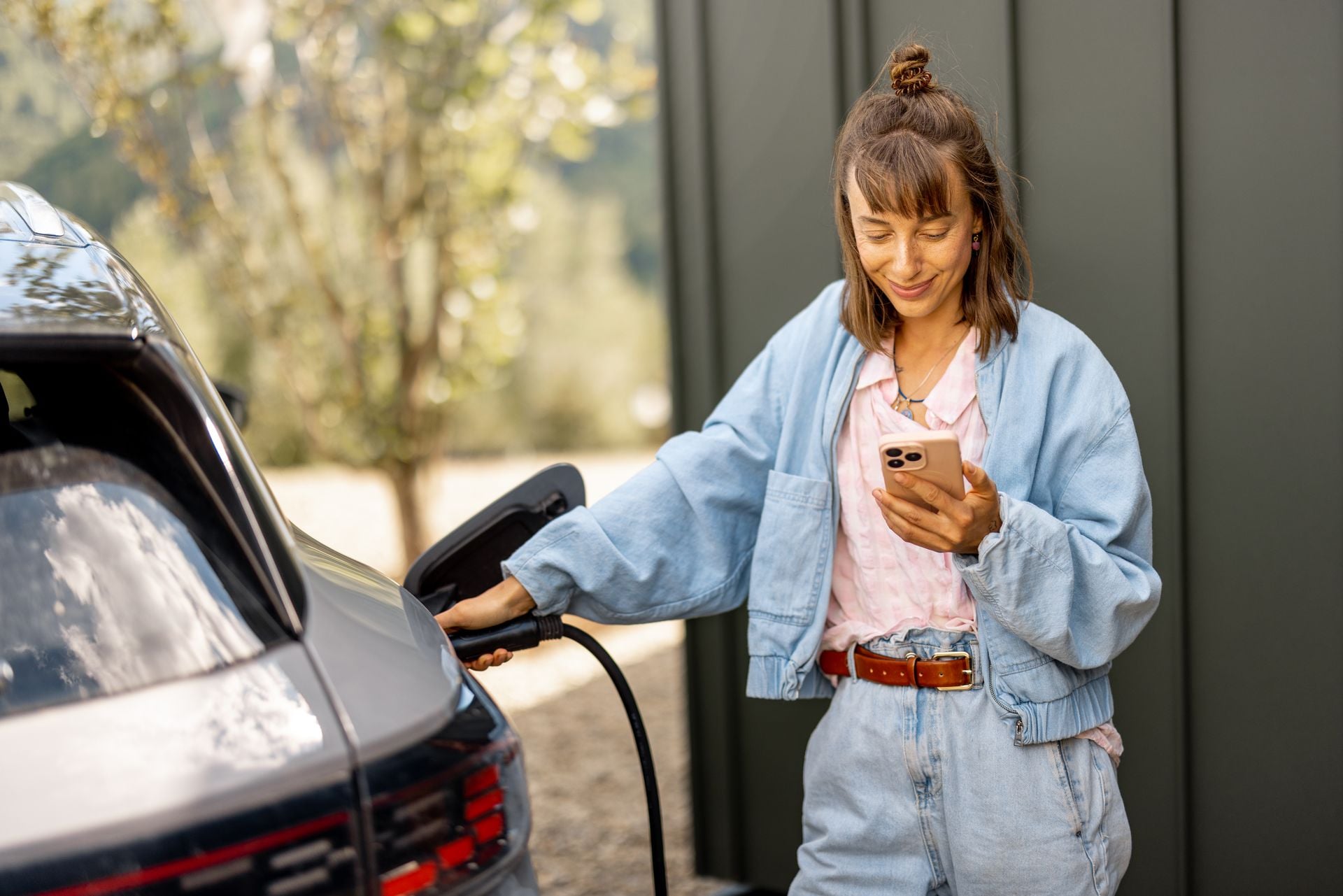 Woman charging electric vehicle