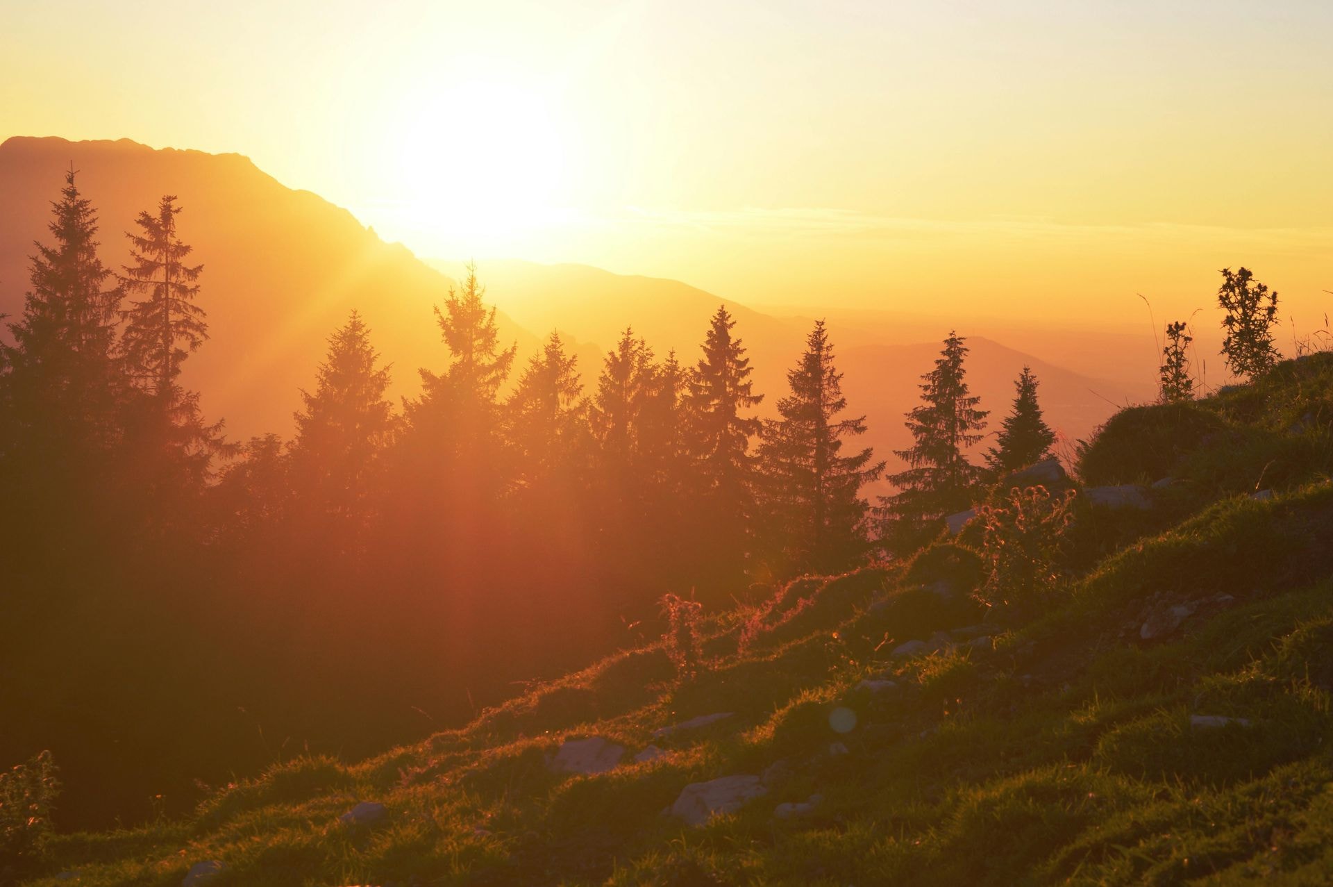 sun sets behind a mountain range