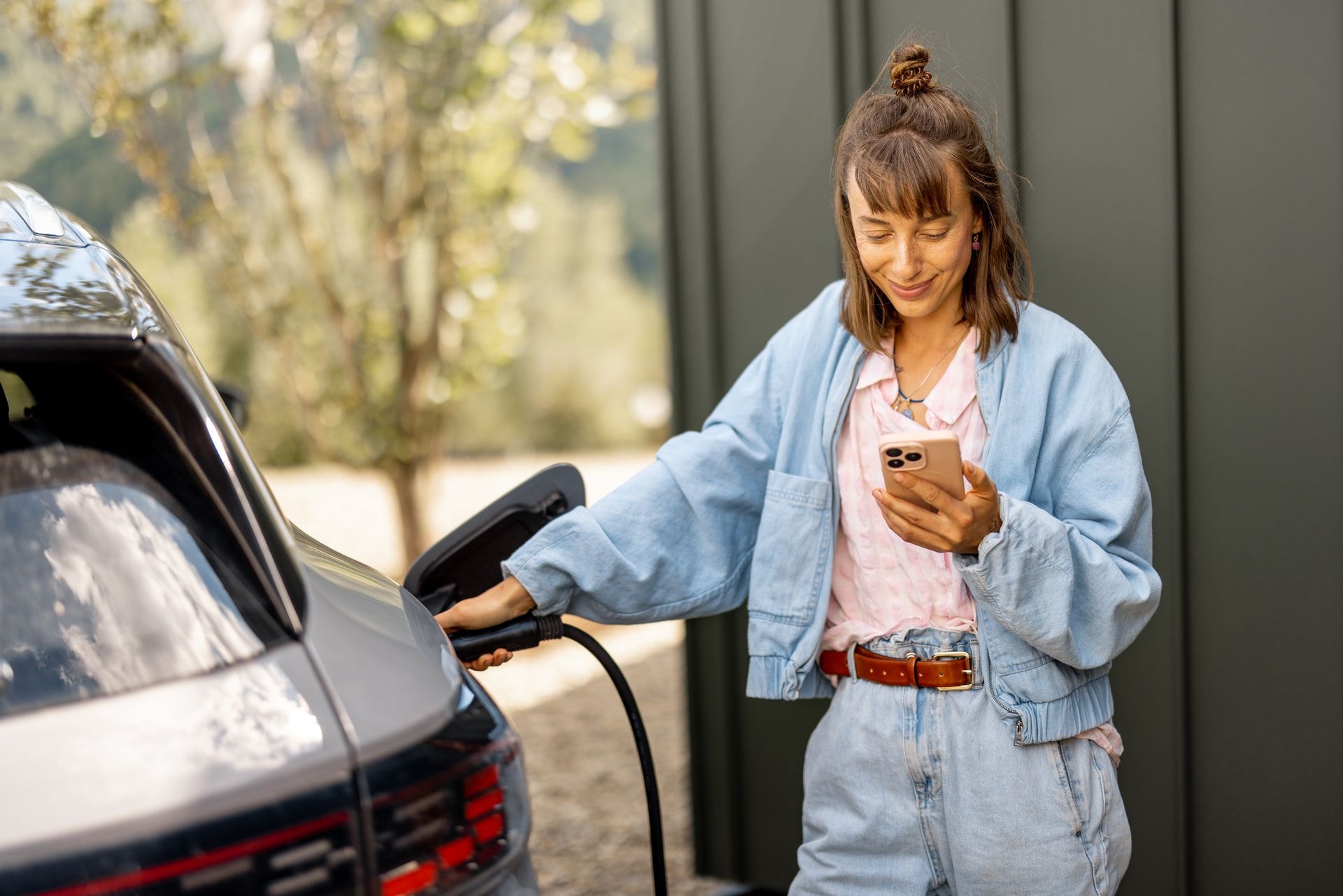 Woman charging electric vehicle